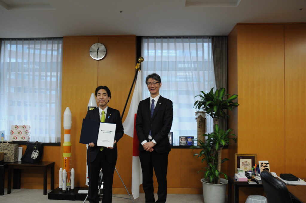 島田座長代理から推進方策の手交を受ける城内大臣